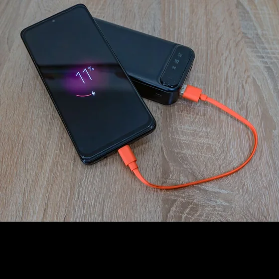 A smartphone charging from a power bank.