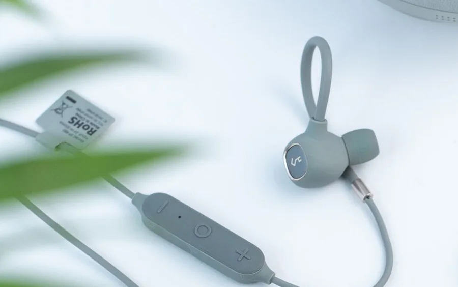 Wireless earphones and headphones laid out on a light surface.